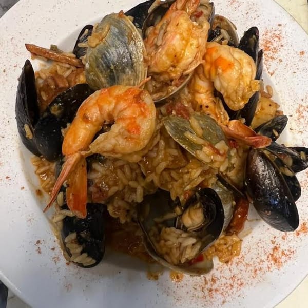 Monalisia's seafood risotto with mussels, clams, and shrimp on a white plate.
