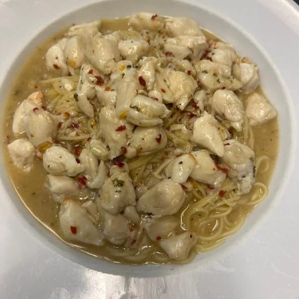 Monalisia's Italian crab meat pasta with chili flakes and a light sauce in a white bowl.